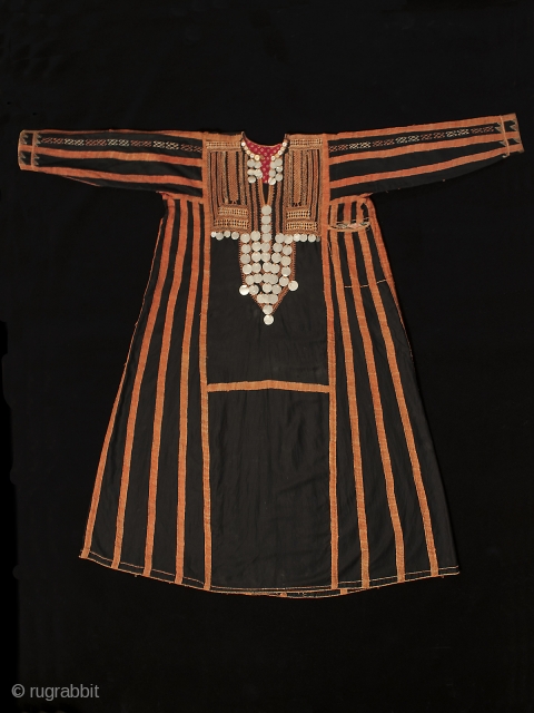 A traditional dress worn by women in the Western Desert of Egypt, this fustan is ornately decorated with thin silver coins, buttons and very fine cotton embroidery. There is a pocket on  ...