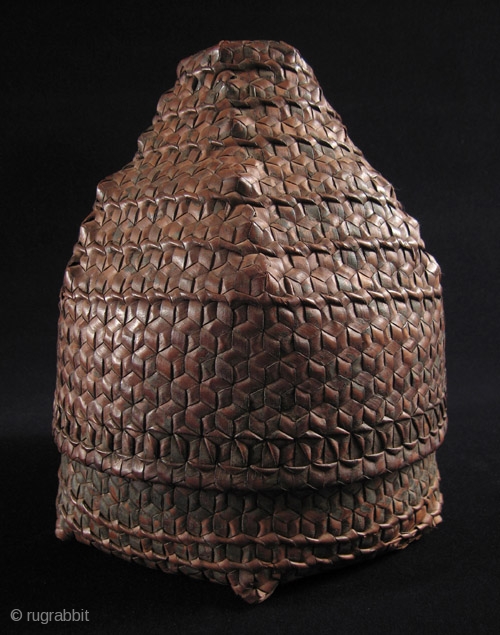 This is a beautifully shaped woven storage basket from Timor. It measures 11” high by 8” wide and has a small hole in one corner. Early 20th century.     