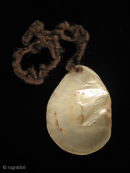 This is a luminous pearl shell pubic cover from the Kimberly area of Western Australia, worn by  men during certain ceremonies. It still has the human hair rope that would wrap  ...