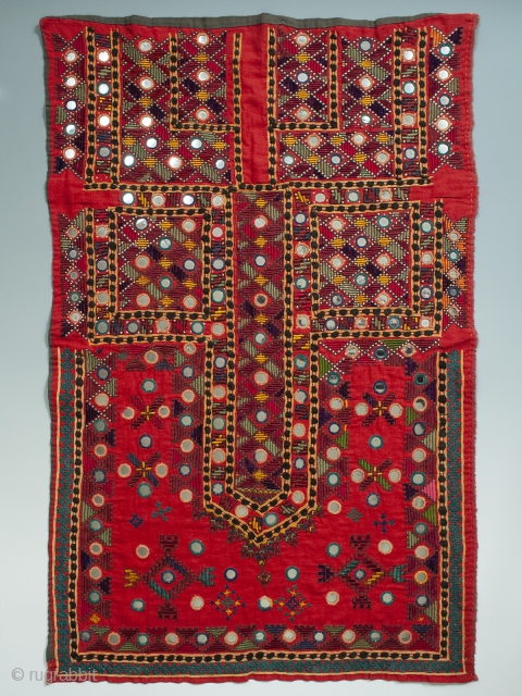 A multi-colored embroidered shirt front from the Sindh region of Pakistan. Bright red cotton is completely covered with silk and cotton thread embroidery and mirrored disks scattered throughout. In great unused condition  ...