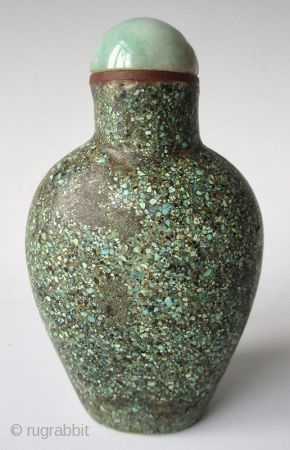 Antique Chinese Turquoise Encrusted Snuff Bottle

Antique Chinese snuff bottle of a flattened oval form with recessed foot, encrusted with finely crushed turquoise. The stopper has a jadeite lid with bright apple green  ...