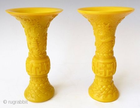 Antique Chinese Pair of Yellow Peking Glass Gu Vases

An elegant pair of Chinese monochrome yellow peking glass gu vases with relief carvings of waves, archaic scrolling serpents, one vase with a pair  ...