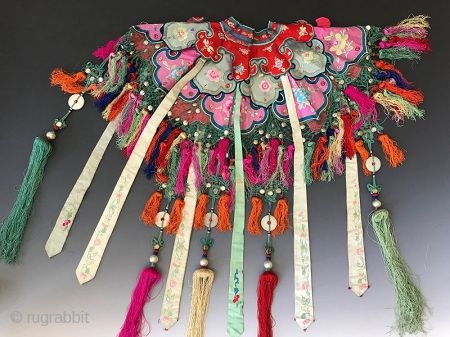 Chinese Embroidered Cloud Collar

A delicate antique Chinese child's collar with stitch work. The fine knitting on the edge is embellished with small white metal discs and multicolored tassels. The shawl collar is  ...