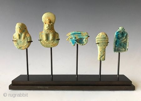 Rare Faience Egyptian Amulets

Five clay faience (blue -green) amulets from Egypt that are mounted on a custom stand. The amulets are a Pharaohs head, a sphinx, a Wedjat eye (Eye of Horus),  ...