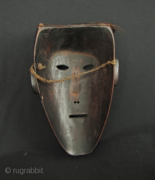 Nepalese Hill Tribe Mask:
Well carved tribal mask from Nepal. This is made from a heavy, densely grained wood with an old Nepalese rupee set in the forehead and an animal hide goatee  ...