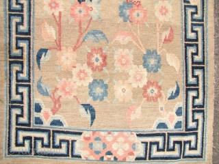 Tibet Khaden Rug: Tibetan carpetwith auspicious floral pattern and ”meander” border.  L: 168cm/67in and W: 84cm/33in. There is some wear in center and it is faded on one end giving it  ...