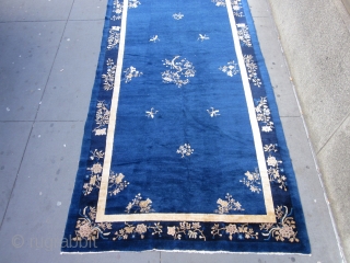 An antique Peking carpet in a very rare gallery format,with a mostly open luminous royal blue ground.The wool is glossy with a desirable patina.There is slight carving to further emphasize the design  ...