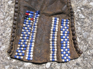 Plains Indians front piece for a pipe bag, Crow Nation, Montana, 2nd QTR 19thC, glass pony beads and large barrel shaped silver beards on hide, sewn with sinew and narrow strips of  ...