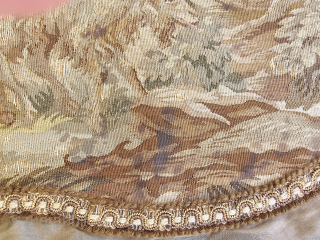 Antique French Aubusson tapestry, hand woven silk, 18thC, goats at a well, the fragment has been sewn to a gray pillow sham, exposed foundation threads, stains, the approximate size of the sham  ...