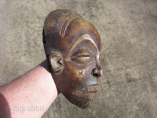 Vintage African mask, hand carved wood, Baule People, Ivory Coast, exhibiting facial scarification, a small mask like this would be used as a central feature of an elaborate mask, expanded with raffia,  ...