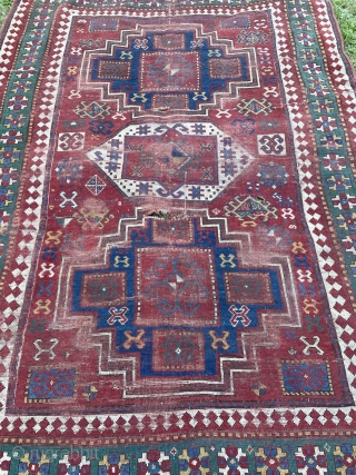 Dirty bashed up Kazak. Couplw of holes, rips and tears bur great colours and design. Ans despite its issues a great rug. Turkish repair special? 7 x 5 feet    