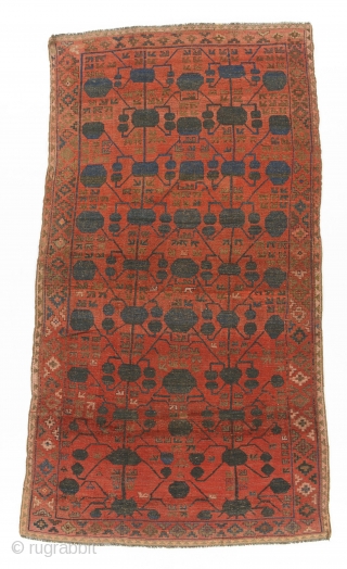 Kyrgyz giliam, Ferghana, Central Asia, late 19th century, 360 by 206 cm, an exceptionally rare for Kyrgyz carpets pomegranate design (Kashgar nuska) borrowed from Chinese Turkestan's silk carpets, natural colours, signed LR  ...