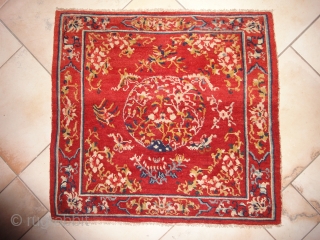 A Tibetan square with an intense red background. Very tightly knotted. Cm 74 x 79. Beginning of 20th century or earlier.            