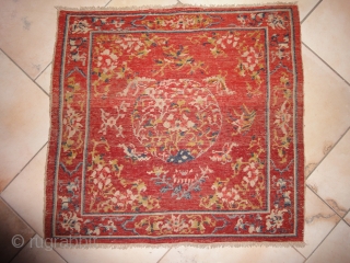 A Tibetan square with an intense red background. Very tightly knotted. Cm 74 x 79. Beginning of 20th century or earlier.            