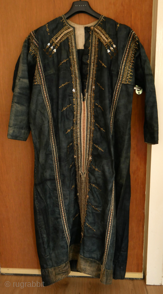 Rare Yemen bridal or festive dress (zanna) made of indigo dyed cotton, decorated with a variety of small, applied metal discs, metal chains, pieces of shell, as well as various embroidery stitches.  ...