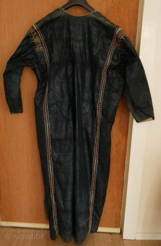 Rare Yemen bridal or festive dress (zanna) made of indigo dyed cotton, decorated with a variety of small, applied metal discs, metal chains, pieces of shell, as well as various embroidery stitches.  ...