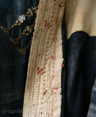 Rare Yemen bridal or festive dress (zanna) made of indigo dyed cotton, decorated with a variety of small, applied metal discs, metal chains, pieces of shell, as well as various embroidery stitches.  ...