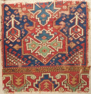 Two fragments of an exceptional 18th century blue-ground Bergama area rug with a curled tendril palmette border. Each approximately 2'6"x2'6".             