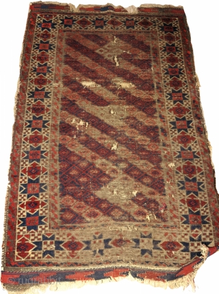 worn antique Khorosan Baluch rug with great star border. Diagonal stripes with a pile rendition of flatweave design. corrosive browns.


             