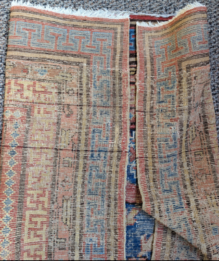 Rare unusual Khotan rug with a seldomly seen central medallion variant and corner pieces. Fret guard border is drawn very freely with little regularity. Worn, scattered repairs,both ends are rewoven.   