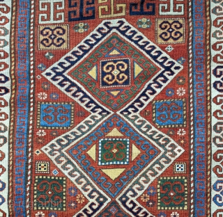 Karachopf Kazak, late 19th century. 74" x 51". a cheerful Kazak featuring a well-drawn ram's horn ivory border framing a red ground with an ivory outlined triple medallion. The ram's horn motif  ...