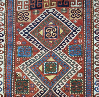 Karachopf Kazak, late 19th century. 74" x 51". a cheerful Kazak featuring a well-drawn ram's horn ivory border framing a red ground with an ivory outlined triple medallion. The ram's horn motif  ...