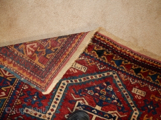 KAZAK OR KUBA RUG WITH BLUE SIDES , THIN RED WEFTS , AND BRAIDED ENDS ...DATED 1898
A BIT OF WEAR- 40 X 60 INCHES         