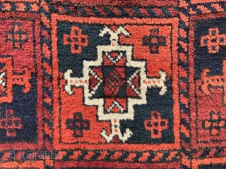 Baluch rug with overall design of Turkmen 'ayna' guls in full pile with complete plain-weave skirts - 2.44m x 1.17m (8' 0" x 3' 10").        