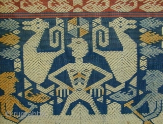 East Sumba Ceremonial Sash. Woven in supplementary-warp technique. Yellow and blue details are painted in after the weaving is completed. 199x57 cm. Mid-20th Century. Background colours are natural indigo and brown derived  ...