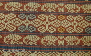 East Sumba Ceremonial Sash. Woven in supplementary-warp technique. Yellow and blue details are painted in after the weaving is completed. 199x57 cm. Mid-20th Century. Background colours are natural indigo and brown derived  ...