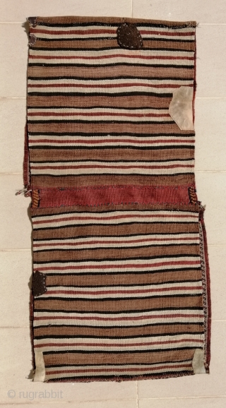 A truly tribal Khamseh (possibility Bāsiri sub tribe) khorjin (saddlebags) from early 20th c. opened at sides. Size closed approx. 41 x 143 cm (1'4" x 4'9"). Excellent shiny wool quality and  ...