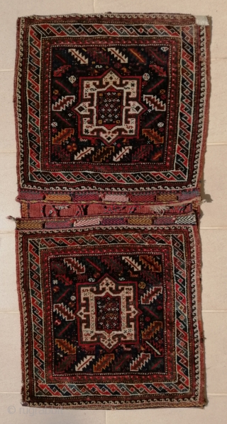 A truly tribal Khamseh (possibility Bāsiri sub tribe) khorjin (saddlebags) from early 20th c. opened at sides. Size closed approx. 41 x 143 cm (1'4" x 4'9"). Excellent shiny wool quality and  ...