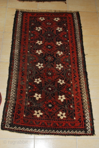 Antique Baluch with a rare plum ground and excellent palette, 2nd half 19th c. 91 x 160 cm. Uneven wear with loss to ends and deep black corrosion. Original sides. Some consolidating  ...