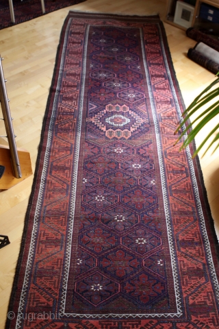 Baluch long rug runner; 118 x 393 cm (3`11“ x 12`11“); after 1920 (?) earlier example from a rare size for Baluch rugs; Main field with a lattice which contains alternating diagonal  ...