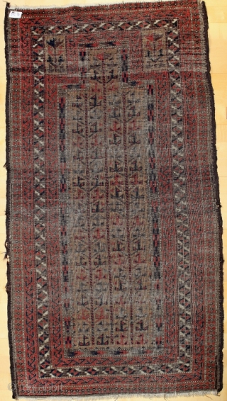 Baluch prayer rug; 86 x 156 cm (2`10“ x 5`2“); around 1900; fragment; apart from condition a very interesting study piece; main field and hand panels are filed with trees of life,  ...