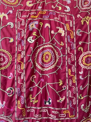 Lakai suzani embroidered in chain stitch (worked with a tambour hook) 
on a very traditional red cotton ground with the typical good luck motifs: circles, representing the heavens, flowers and horns. The  ...