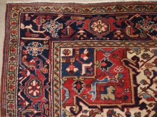 Antique Persian Heriz carpet with a traditional medallion design, medium red field colour with red and blue spandrels. Classic dark indigo blue border that is very well drawn. The central medallion in  ...