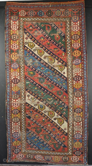 A good Karabag rug with juicy colours, including a particularly vivid green, worn and various problems, but very cheap and possibly restorable. 19th century. 223 x 110      