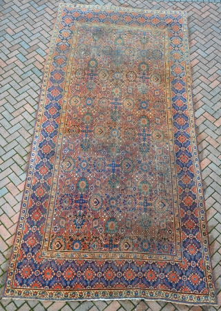 An antique Khorrasan carpet, some wear but complete, still retaining its original sides and fine blue kilim ends. 462x220cm. Early 19th century           