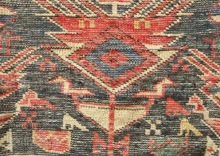 Shirvan rug, 19th century.  Botehs and shrubs of life or shrubbery of a general nature flanked by birds.  The weave is fine.  A section of wear in one of  ...