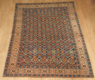 Kuba rug, 19th century.  Deep indigo ground with green, yellow, blue, pink and purple palmettes.  Green main border with kufic motifs.  Excellent condition. 150 x 178 cm   