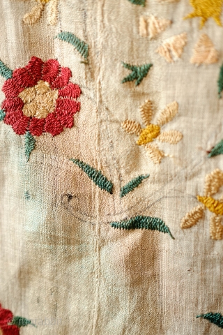 Ottoman Embroidery, 18th Century. Overall floral motif in strong, vibrant colors in silk on linen. The maroon-brownish silk has been coroded in the stems and border outlines. This is a complete suzani.  ...