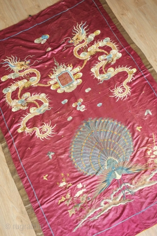 Qing Chinese hanging, late 19th century. The fabulous peacock tands with opened tail in exceptional embroidered detail with two dragons facing each other above.  The dragons are four clawed and are  ...