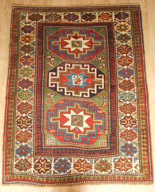 Kazak or Moghan rug, 4th quarter of the 19th century.  Simple, large Memling gul design and a stunning array of colors.  Wonderful lobbed floral border.  159 x 200 cm 