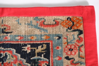 Antique Tibetan mat or seat cover, first quarter of the 20th century, 23" by 30", with original edging and backing.             