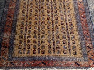 Small antique Baluch camel ground rug with a tree of life variant design, last quarter of the nineteenth century, some wear mainly around the perimeter, edges redone, flat weave ends missing.   ...