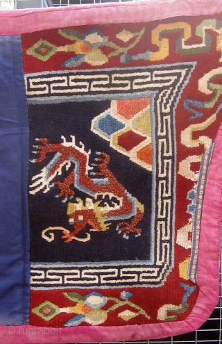 Antique butterfly-shaped Tibetan saddle cover or rug, dragons and mountains on a deep blue field in a spare design usually associated with earlier examples.  Early 20th Century. Traditional red edging (faded)  ...