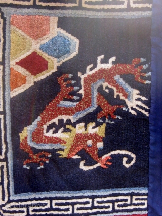 Antique butterfly-shaped Tibetan saddle cover or rug, dragons and mountains on a deep blue field in a spare design usually associated with earlier examples.  Early 20th Century. Traditional red edging (faded)  ...