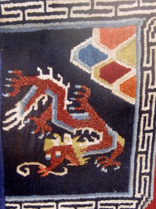 Antique butterfly-shaped Tibetan saddle cover or rug, dragons and mountains on a deep blue field in a spare design usually associated with earlier examples.  Early 20th Century. Traditional red edging (faded)  ...