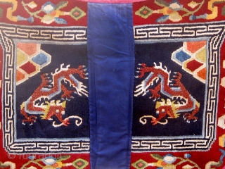 Antique butterfly-shaped Tibetan saddle cover or rug, dragons and mountains on a deep blue field in a spare design usually associated with earlier examples.  Early 20th Century. Traditional red edging (faded)  ...